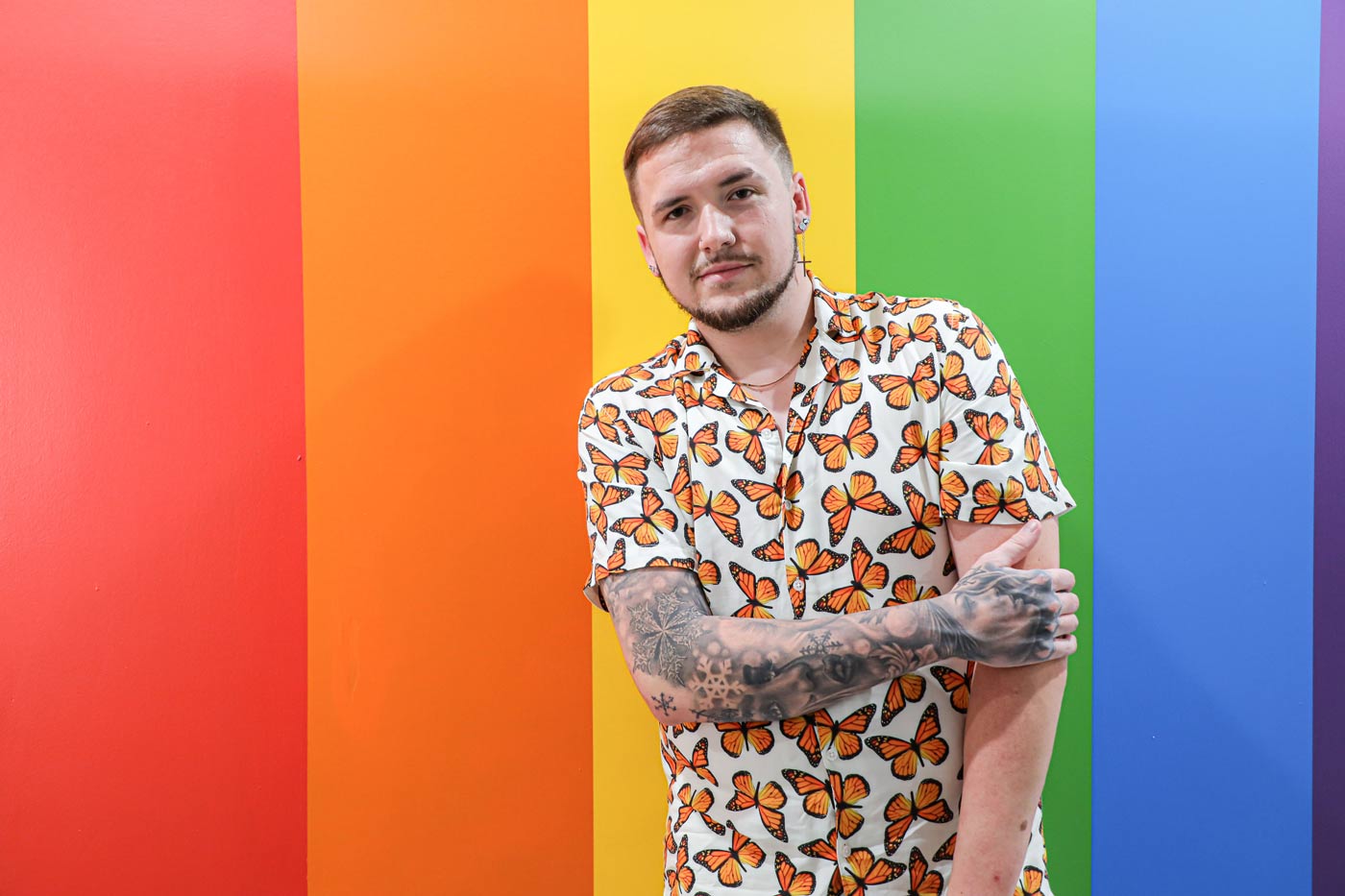 guy in front of rainbow wall